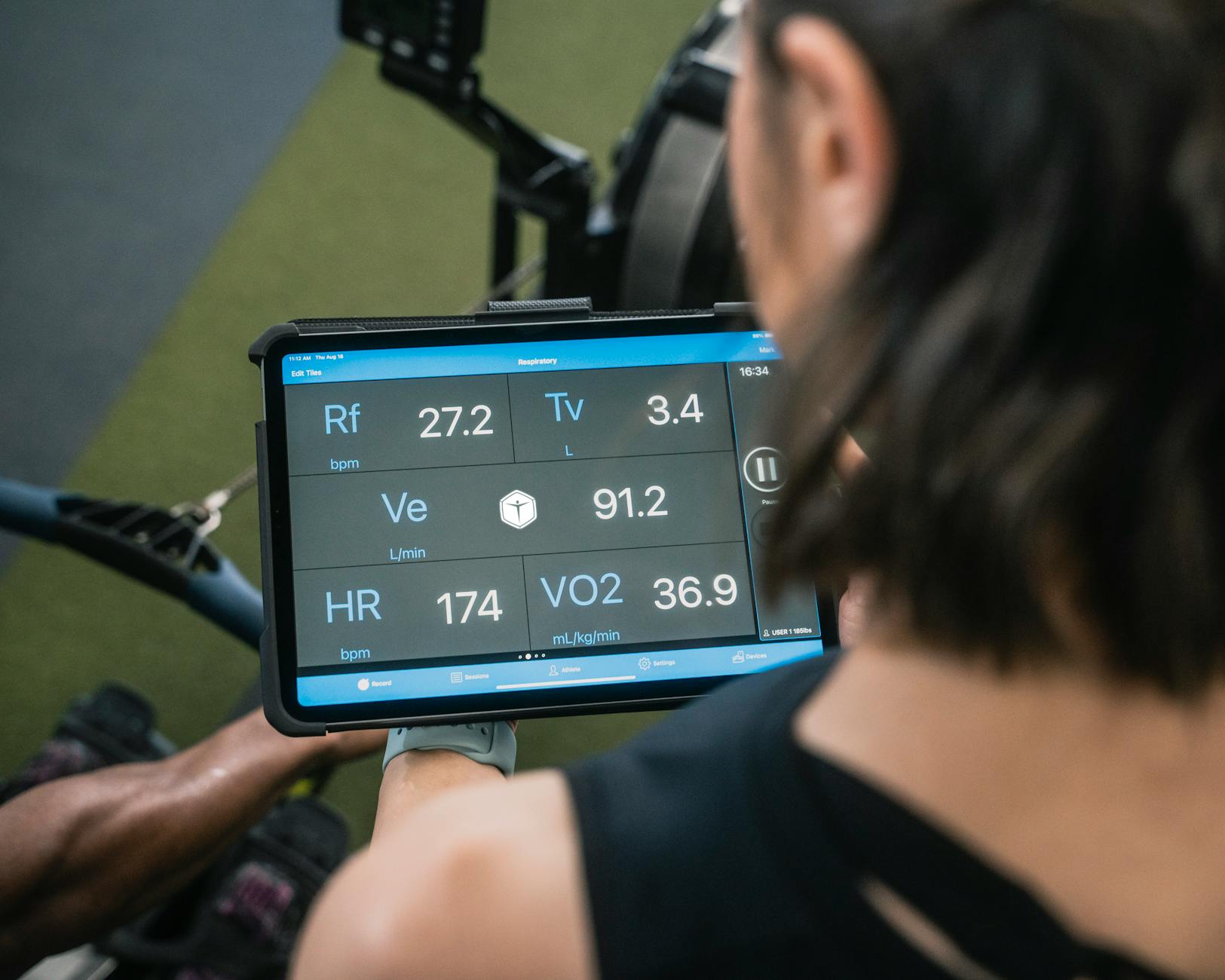 Adult man reviewing fitness metrics on a tablet during a workout session at the gym. (Photo by VO2 Master on Pexels)