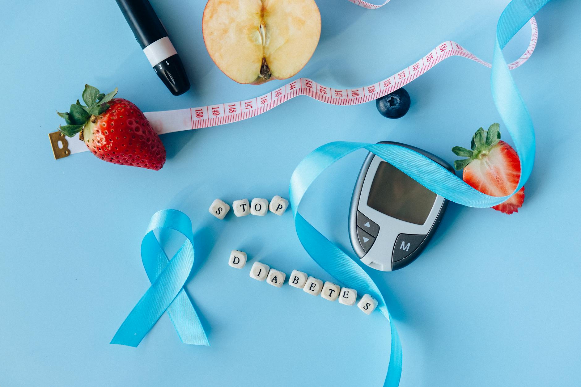 Creative diabetes awareness with fruits, glucometer, and ribbon on blue background. (Photo by Nataliya Vaitkevich on Pexels)