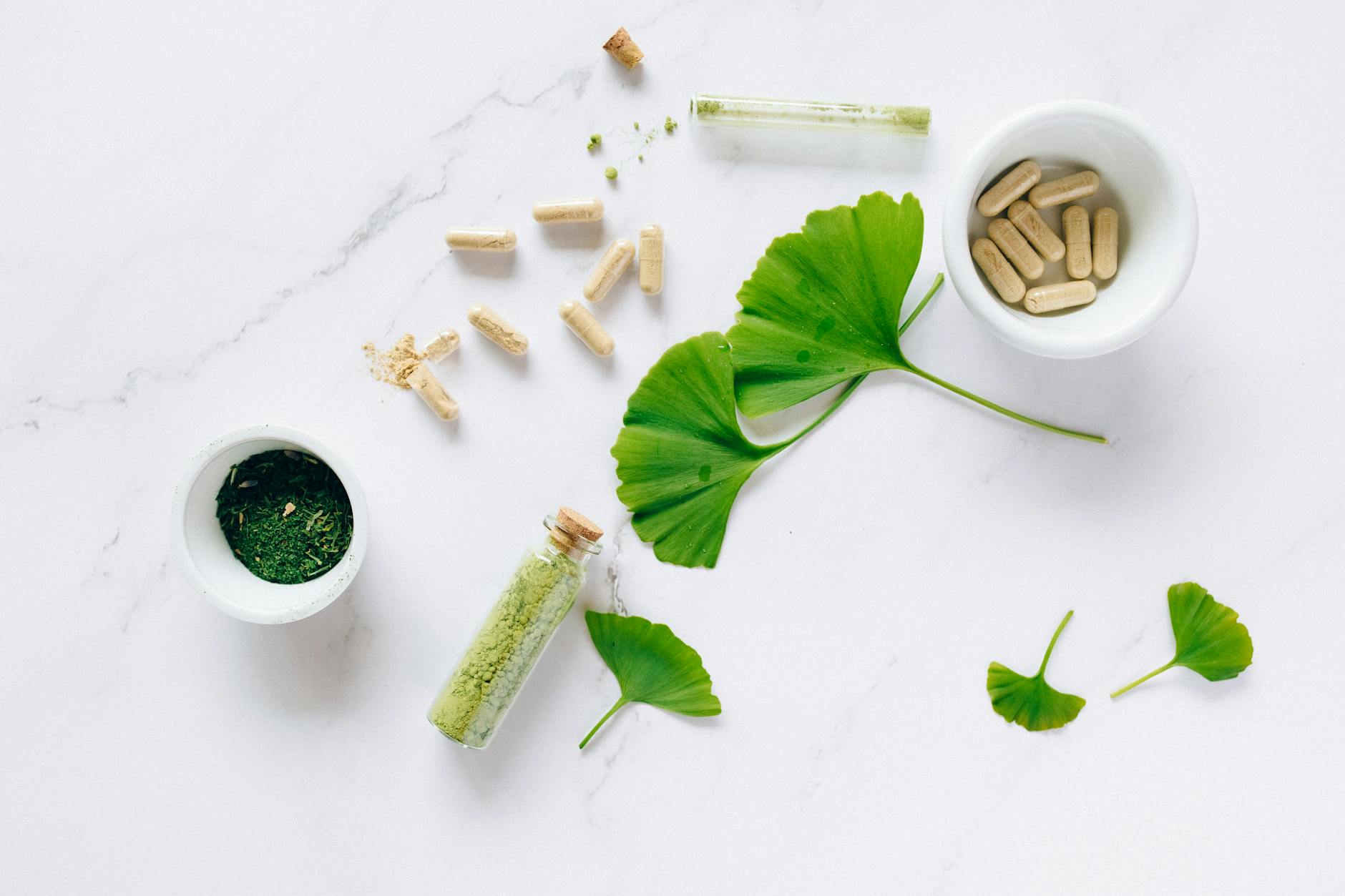 Flat lay of herbal supplements with ginkgo leaves on marble surface, emphasizing natural health r... (Photo by Nataliya Vaitkevich on Pexels)